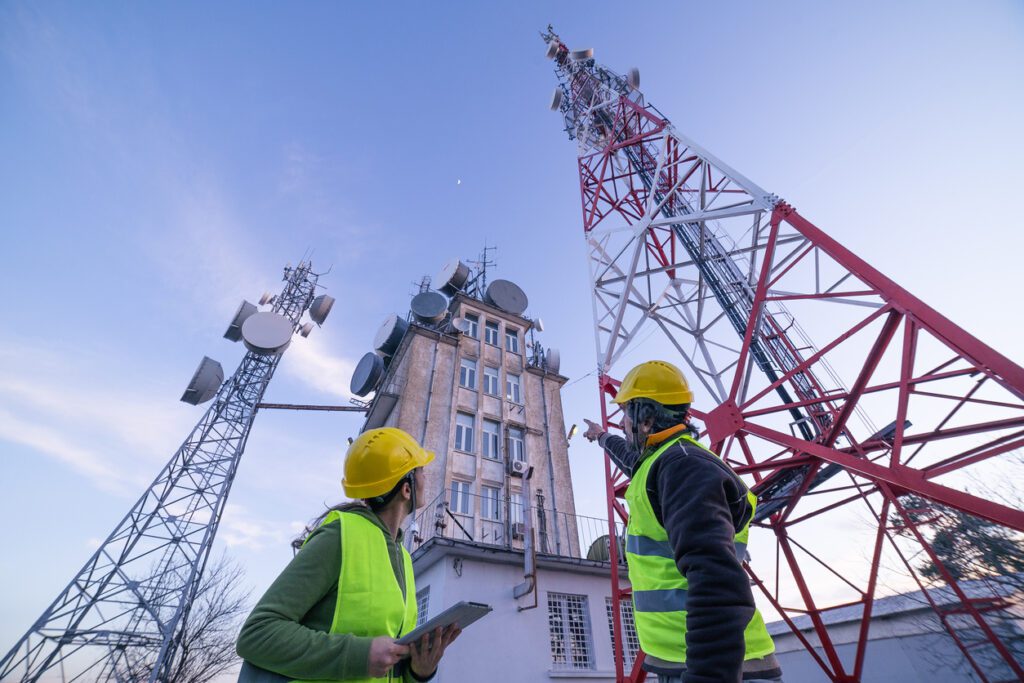 Engineers discussing a telecoms tower